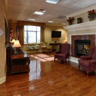 A cozy living room with a fireplace, comfortable seating, and hardwood floors.