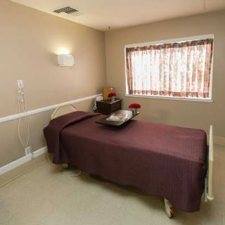 A minimalist bedroom with a single bed and a tray of flowers on top.