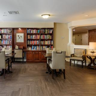 A cozy library space with shelves full of books and seating arrangements for reading.