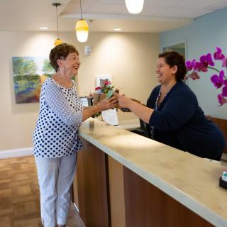 A woman receiving assistance at a reception desk.