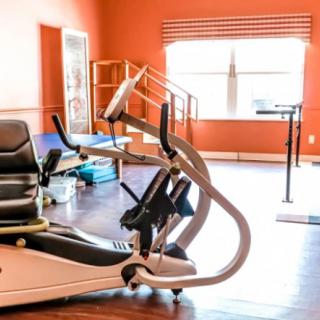 A well-lit gym equipped with various exercise machines.
