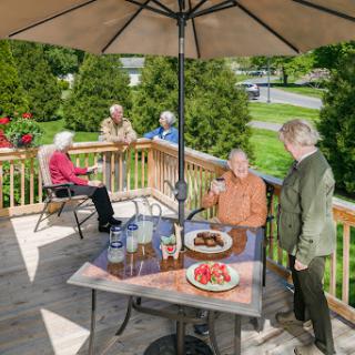 A cheerful gathering with friends enjoying a meal on the deck.