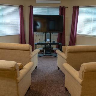 A cozy living room setup with armchairs facing a television.