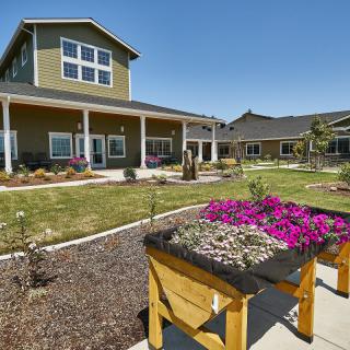 A well-maintained garden with vibrant flowers in front of a spacious house.