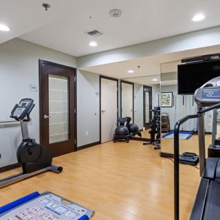 A modern indoor gym with various exercise equipment including a treadmill and stationary bike.