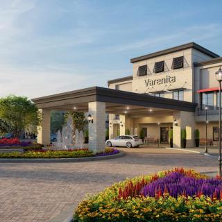 A welcoming view of the Marriott hotel's entrance, featuring well-maintained landscaping and colorful flower arrangements.