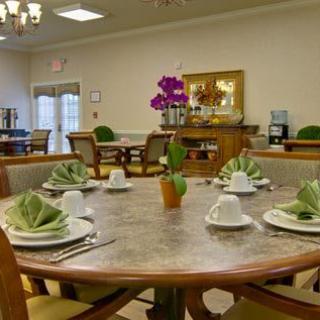 A well-set dining area with neatly arranged tables, adorned with decorative flowers and tableware.