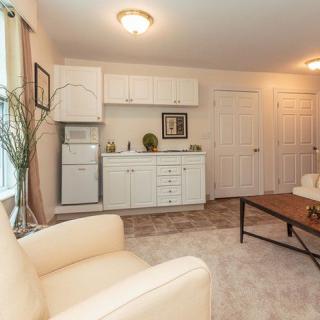A cozy living room with a kitchenette and comfortable seating area.