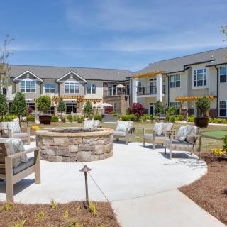 An outdoor seating area with a fire pit at an apartment complex.