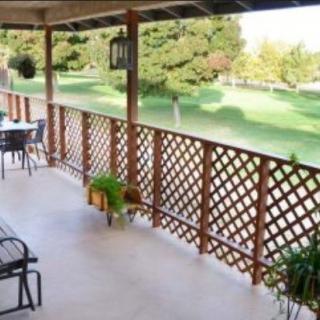 A cozy patio with outdoor furniture, plants, and a scenic view.