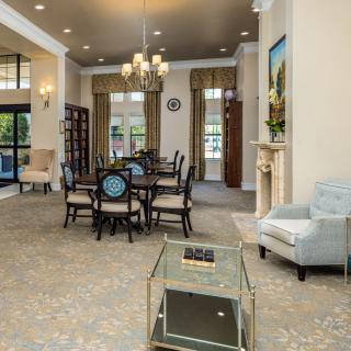 A spacious and elegantly designed living area featuring a dining table, comfortable seating, and a decorative chandelier.