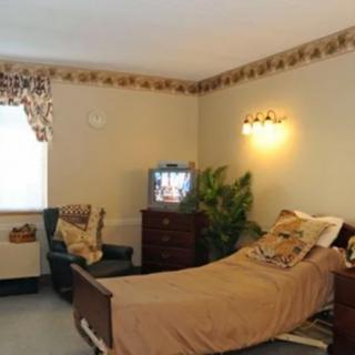 A cozy room with a hospital bed, TV, and comfortable furnishings.