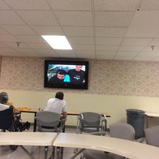 Two people watching television in a communal seating area.