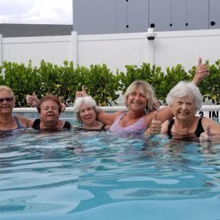 A group of women enjoying a fun time together in a swimming pool.