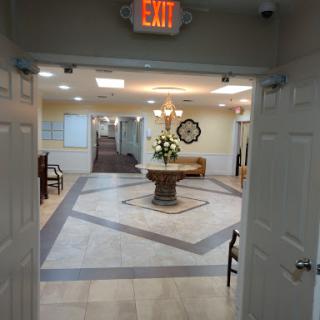 A view of a well-lit reception area featuring a decorative floral arrangement and elegant tile flooring.