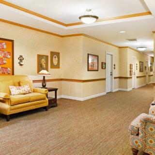 A warmly decorated hallway with comfortable seating and artwork on the walls.