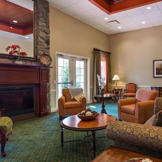A cozy living room with a fireplace, comfortable seating, and warm lighting.