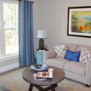A cozy living room with a beige sofa, blue accents, and modern decor.
