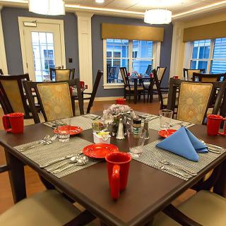 A neatly arranged dining area with elegantly set tables and chairs.