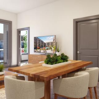 A modern dining room with a wooden table and upholstered chairs, featuring decorative plants and bright lighting.