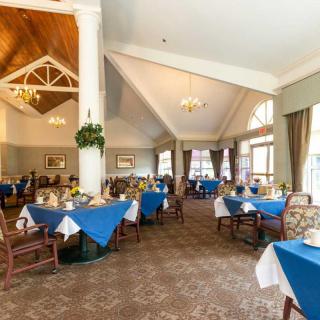A spacious dining room with blue tablecloths and elegant decor.