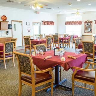A cozy dining area with tables and chairs set for guests.