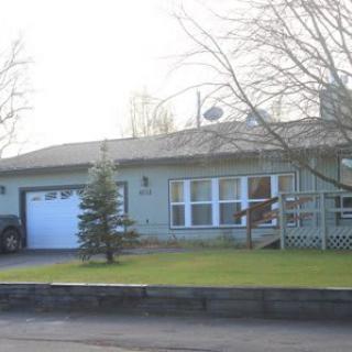 A single-story house with a garage and a front lawn.