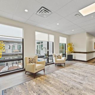 A bright and modern lounge area featuring comfortable seating and large windows for ample natural light.