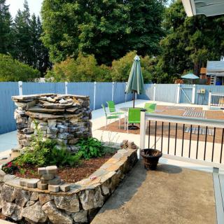 Outdoor garden patio with stone planters and seating area.