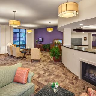 A modern and cozy living room with elegant furniture, ambient lighting, and a warm fireplace.