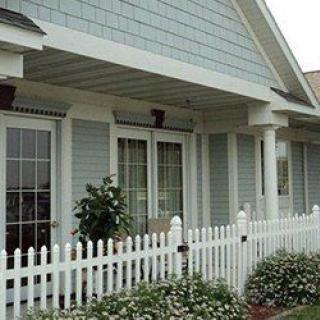 A quaint house with a picket fence and porch.