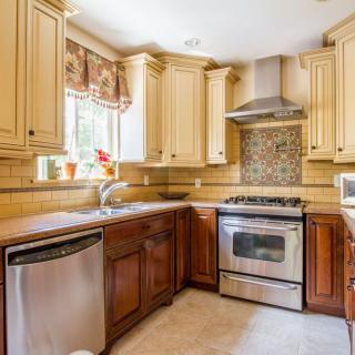 A modern kitchen with stainless steel appliances and wooden cabinets.
