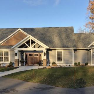 A beautiful single-story residential house with a spacious front yard and driveway, basking in the sunlight.