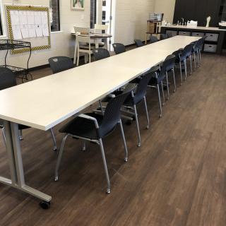 A long conference table with chairs in an office setting.