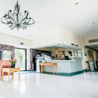 A brightly lit reception area featuring a modern chandelier and minimalist furniture.