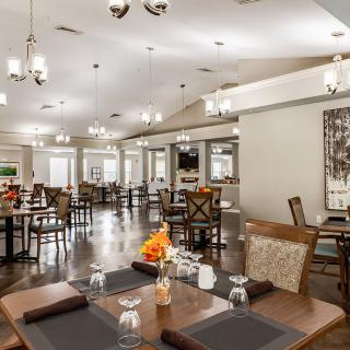 A spacious and elegantly designed dining area with neatly arranged tables and ambient lighting.