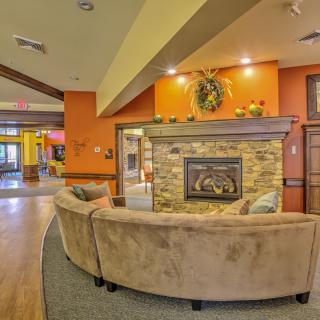 A cozy, modern living room featuring a curved couch and a stone fireplace.