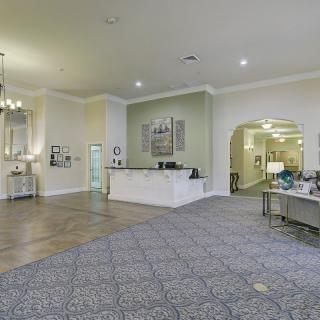 A spacious lobby with a reception desk and elegant lighting.