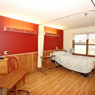 A hospital room with a bed and seating area.