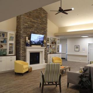 A cozy living room featuring a stone fireplace, comfortable seating, and modern decor.