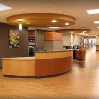 Modern reception area with a wooden desk and flooring.