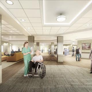 A healthcare professional assisting a patient in a wheelchair within a modern hospital setting.