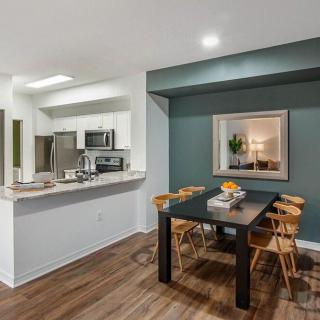 A modern apartment interior showcasing a stylish dining area and kitchen with sleek finishes.