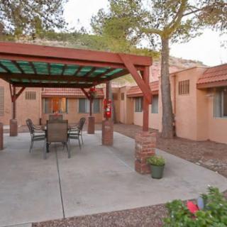 A desert courtyard with a shaded patio area and outdoor seating.