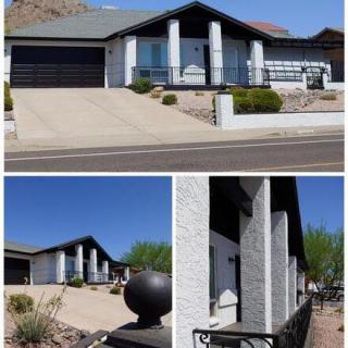 Modern residential home featuring a driveway, garage, and desert landscaping.
