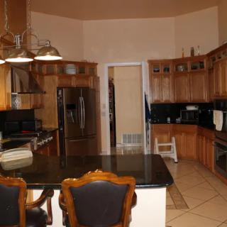 Spacious kitchen with wooden cabinetry and a granite island.