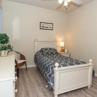 A cozy bedroom with a single bed, decorated with calming tones and minimal furnishings.