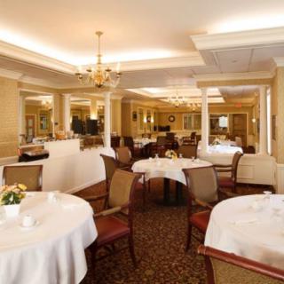 An elegant dining room with round tables and classic chandeliers.