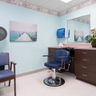 A cozy salon setup featuring a styling chair, a mirror, and a calming blue wall.