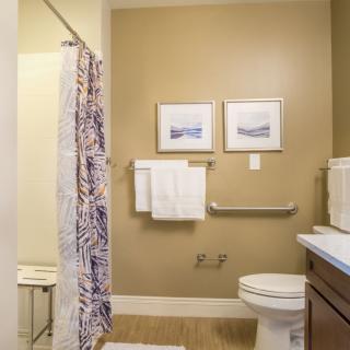 A well-organized bathroom with a shower, toilet, and neatly arranged towels.